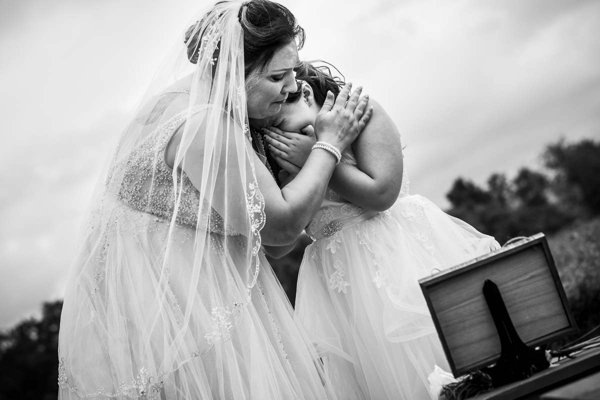 black and white photo emotional authentic real life heritage restored wedding photographer bride holding daughter crying over memorial sign