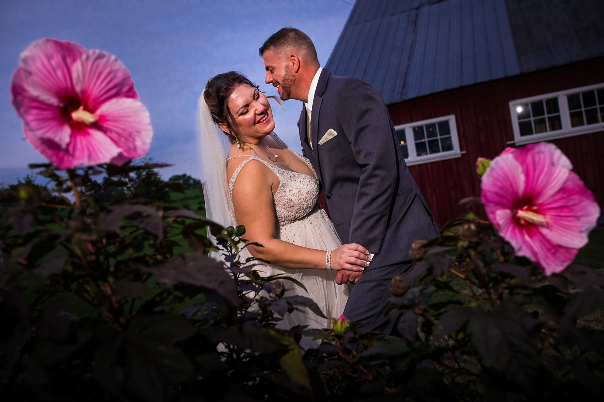 best heritage restored wedding photographer couple smiling looking at each other outside in front of barn