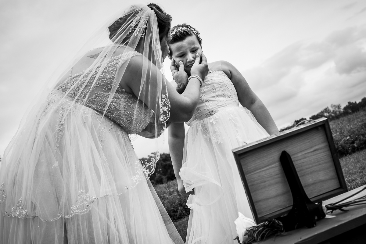 emotional authentic real life wedding photographer bride wiping tears away from daughter crying