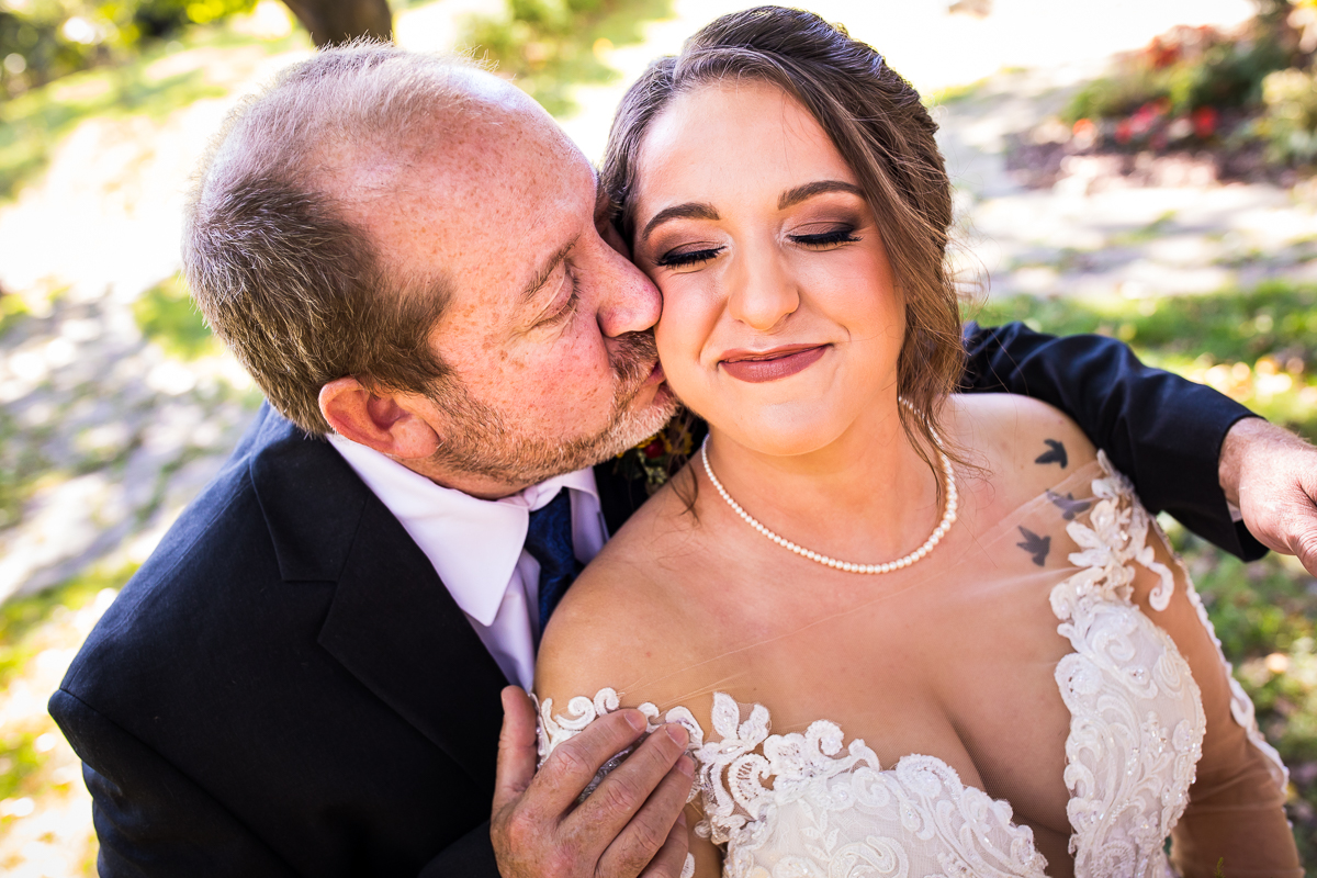 bride's dad kisses bride on cheek after first look