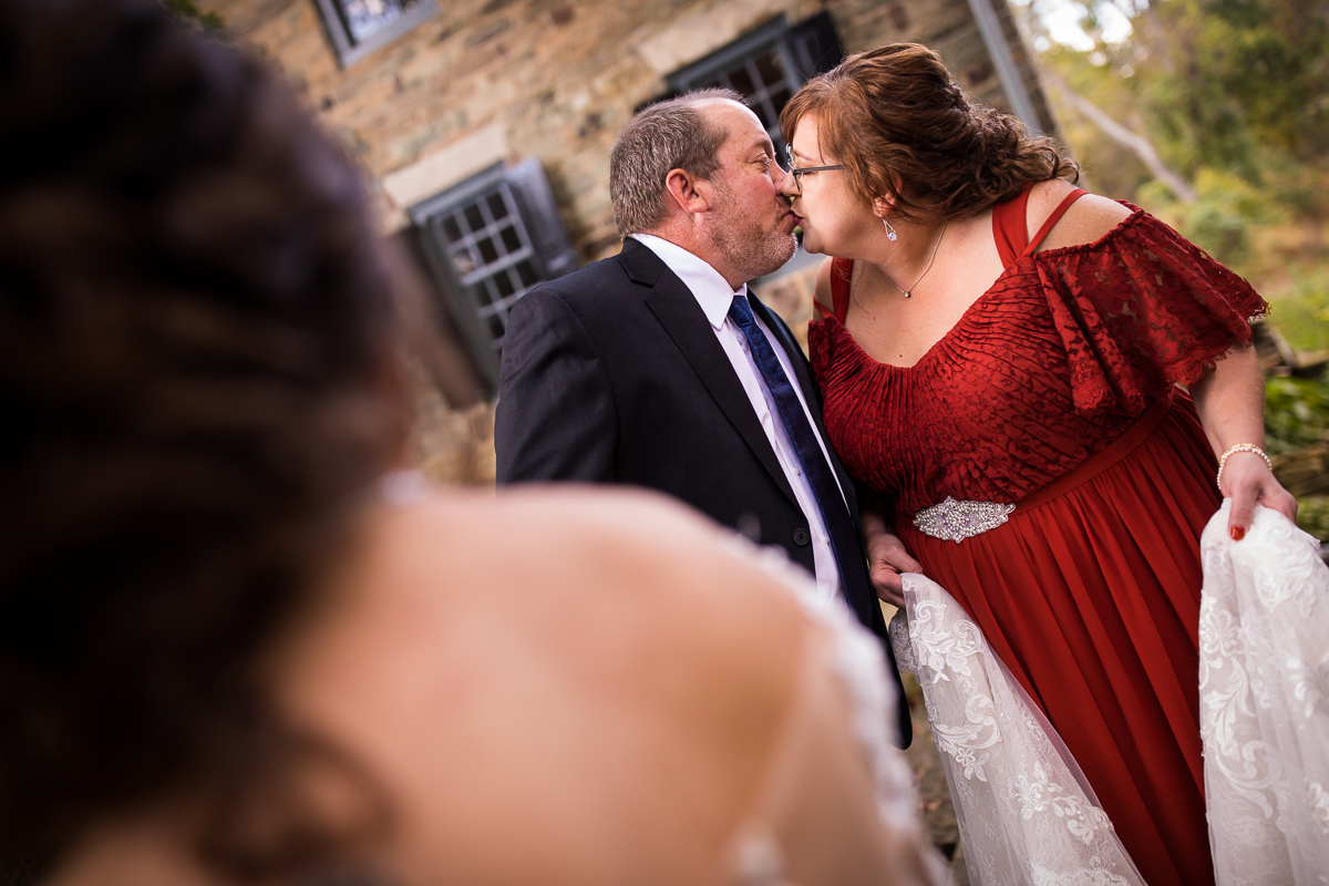 bride's parent share a kiss before leaving for ceremony candid authentic real life