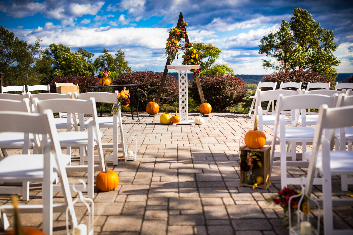 beautiful colorful fall wedding ceremony set up with flowers and pumpkins hauser hill event center outdoor ceremony