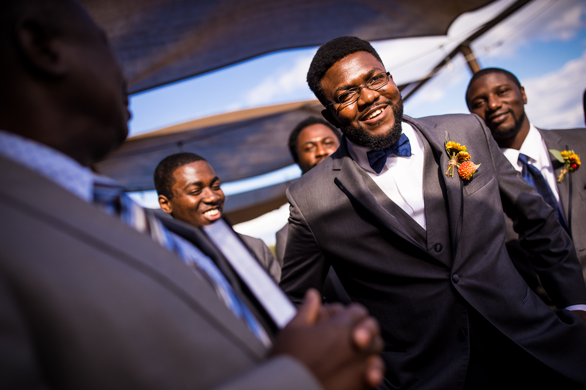 groom and groomsmen talking and laughing together before ceremony begins