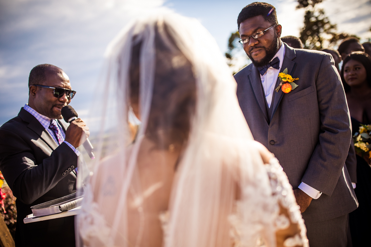 groom looking at bride with officiant next to them during wedding ceremony