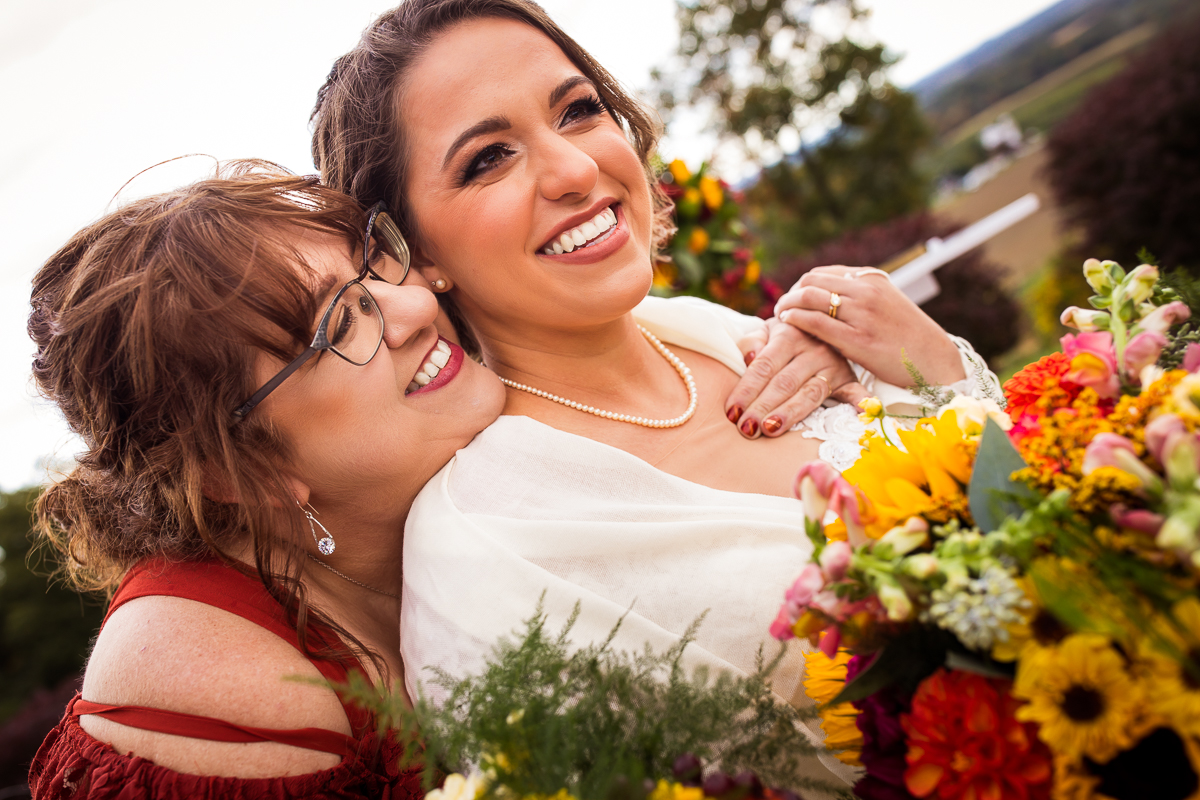 brides mom giving her a hug after ceremony smiling touching hands