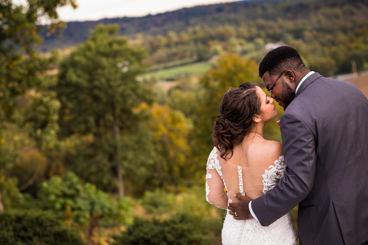 bride and groom leaning in for kiss with trees and hills behind them gettysburg pa fall wedding
