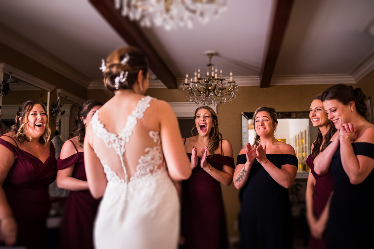 bride first look with bridesmaids smiling and clapping