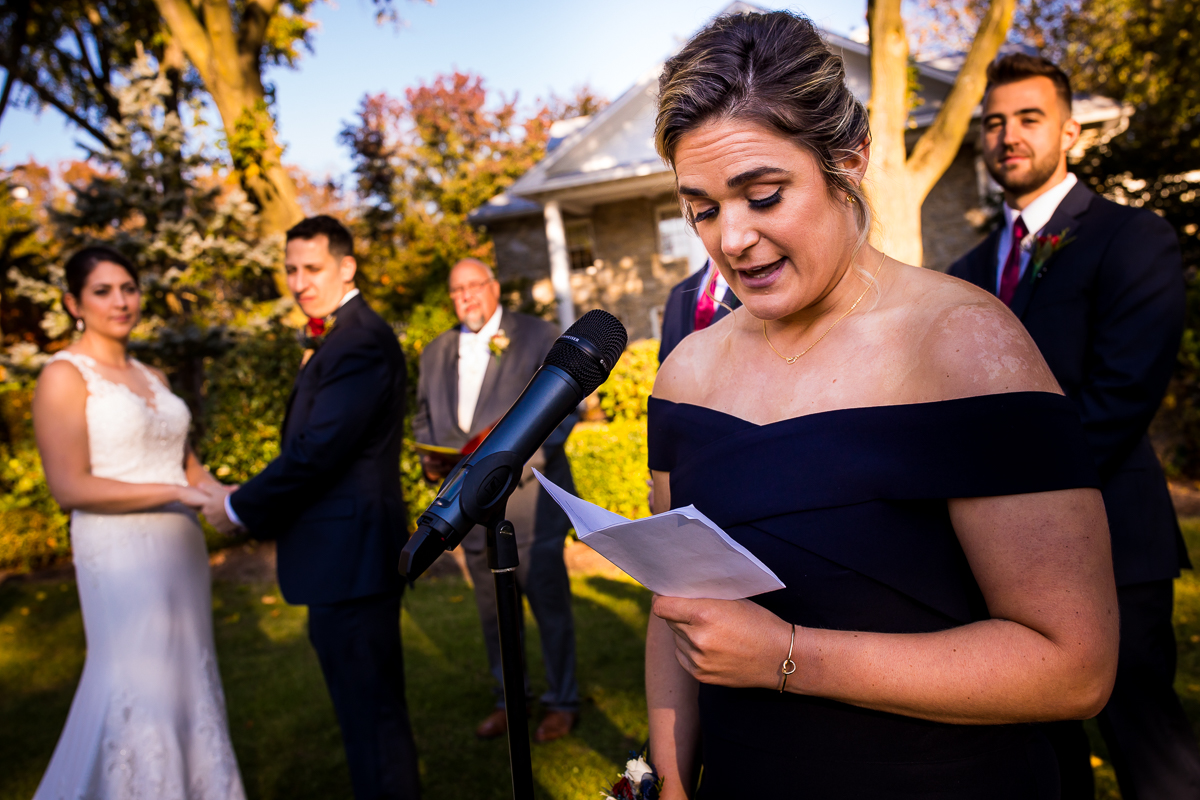bridesmaid reading passage during wedding ceremony as bride and groom look on 