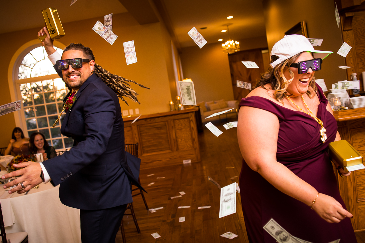 wedding party members entering reception holding money gun with fake money flying all over wearing sunglasses