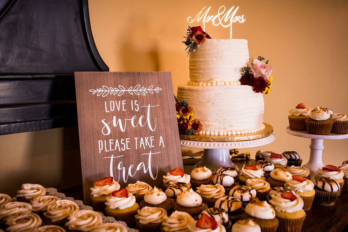 cake and cupcake wedding dessert table with cute sign love is sweet 