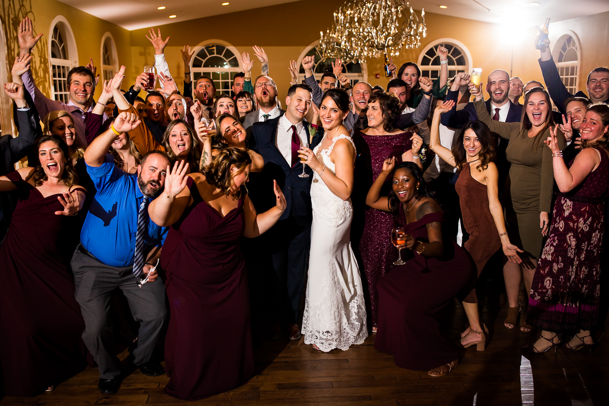 bride and groom with all wedding guests on dance floor smiling and laughing group photo Linwood estate wedding photographer