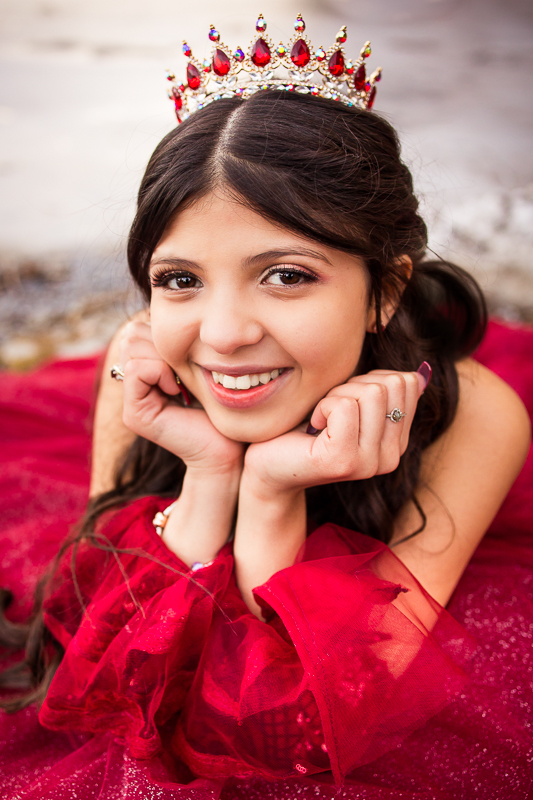 senior portrait photographer central PA girl with face in hands smiling looking at camera wearing red jeweled crown