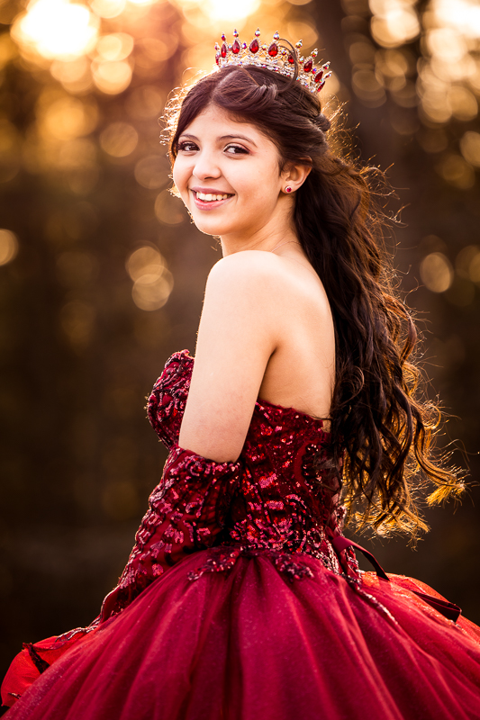 girl smiling wearing red dress looking at camera wearing crown and gloves golden hour best central pa senior portrait photographer