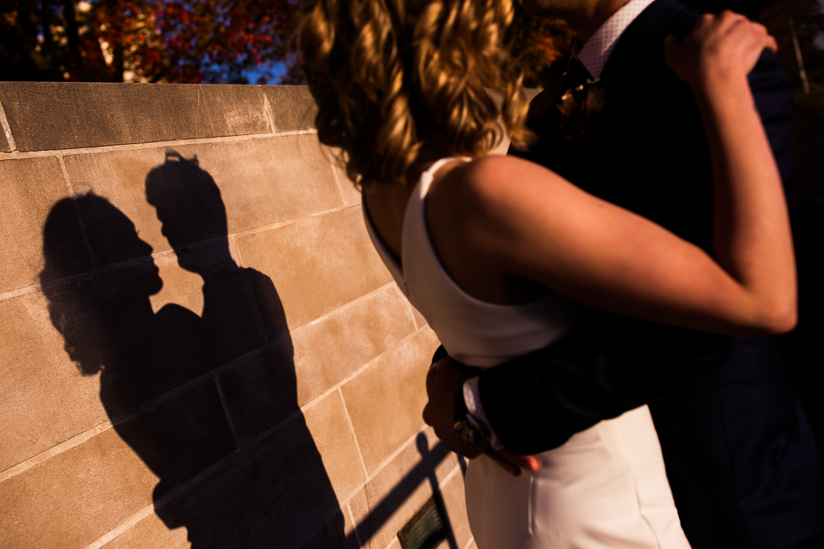 Creative photography which captures the couples shadows on the brick wall embraced in each other's arms