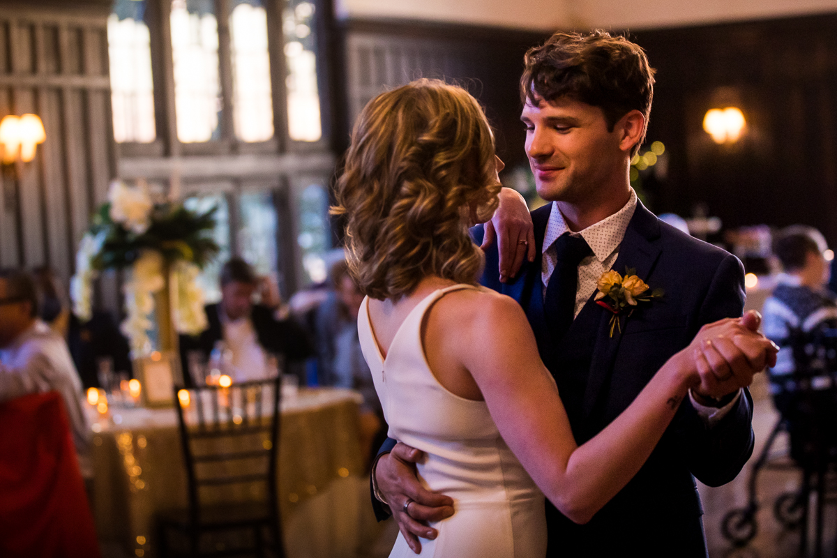 Image of the couple dancing together for their first dance with the groom looking at the bride and smiling