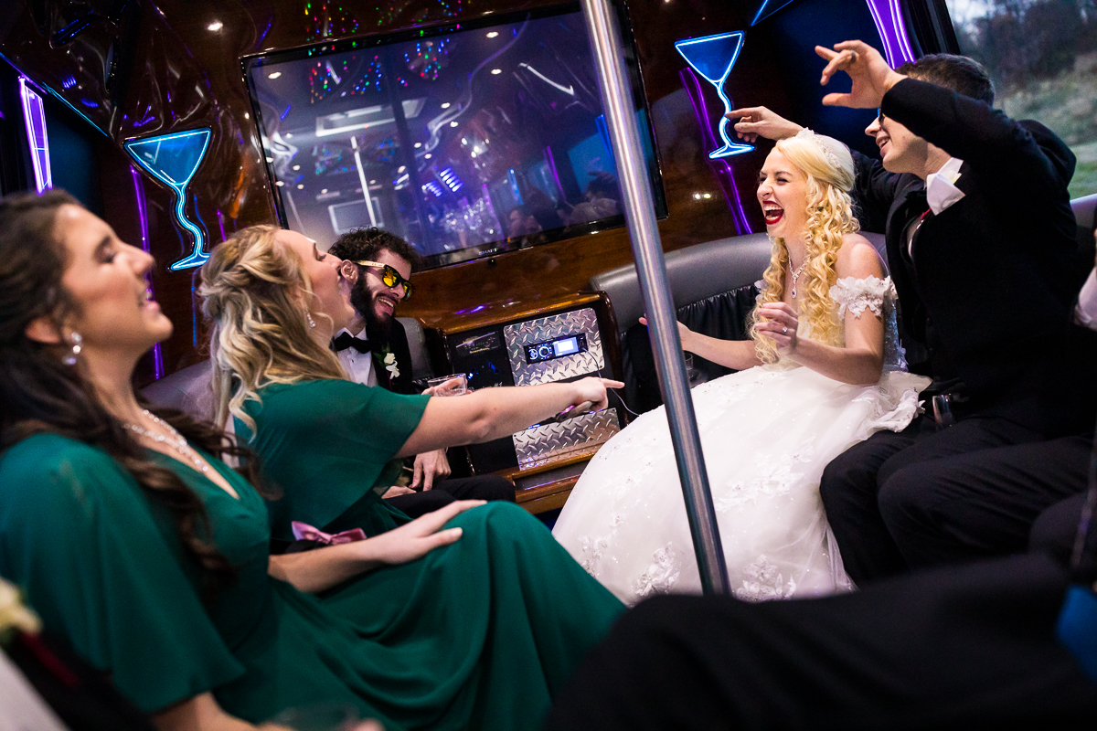 Colorful photo of the wedding party inside of a limo heading to the wedding reception