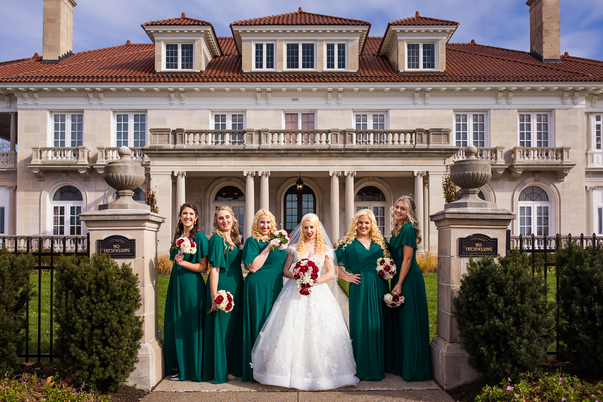 Bride and her bridesmaids wearing green posing outside for this King Mansion Harrisburg Wedding