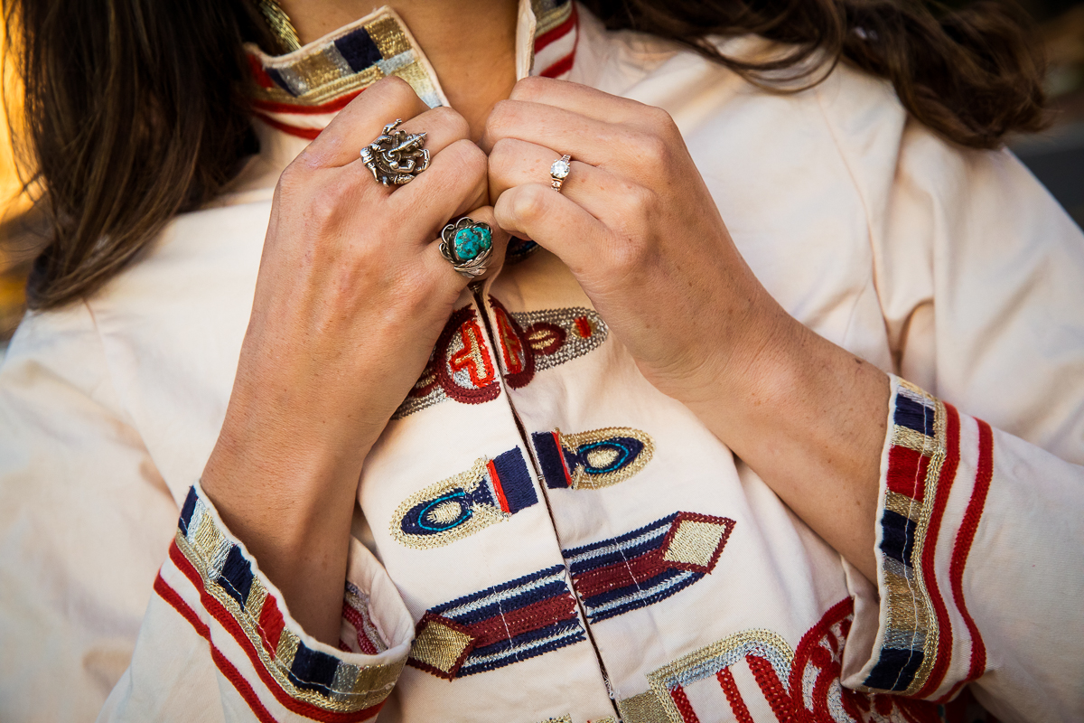 unique, colorful images of travel blogger buttoning up one of her shirts with unique embroidery and several colorful and unique rings taken by Creative Branding Photographer, lisa rhinehart