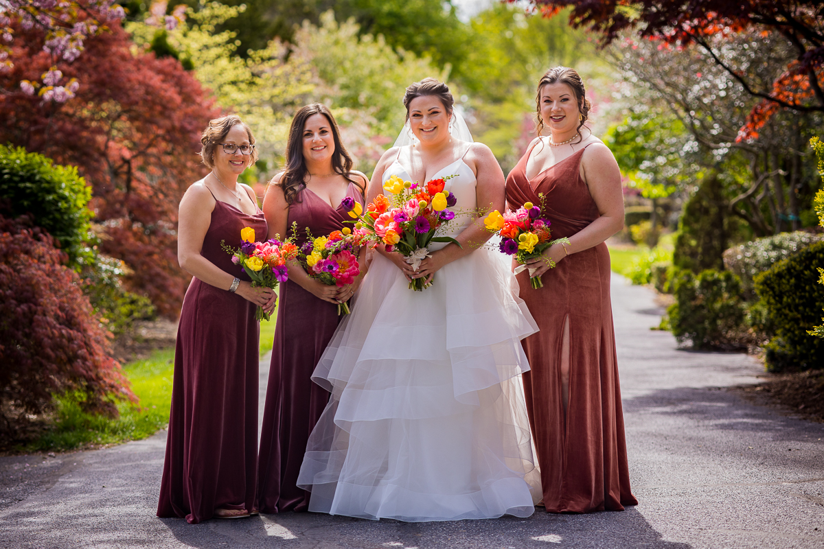 traditional, vibrant image of the bride and her bridesmaids smiling towards the camera before the wedding ceremony at linwood estate
