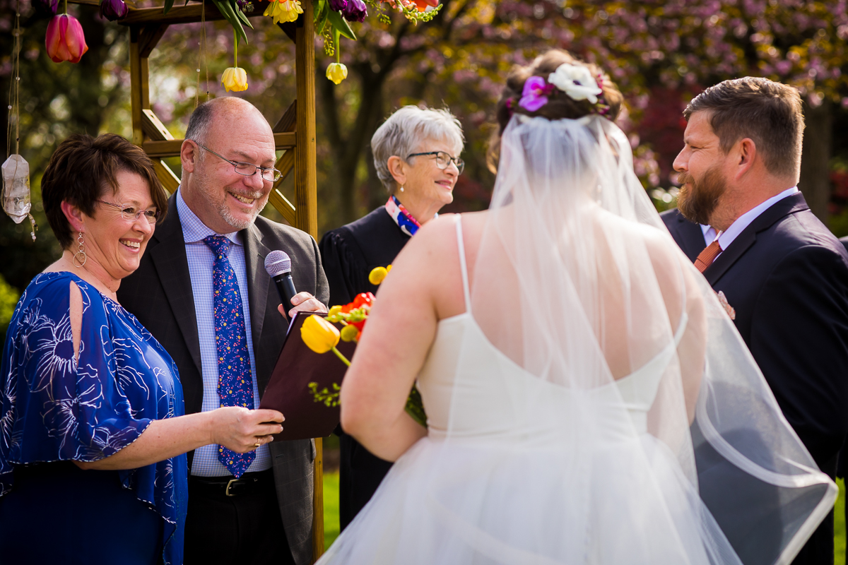 image of the bride and groom smiling at guests of their wedding as they smile back and give a speech during this wedding ceremony at linwood estate in carlisle pa