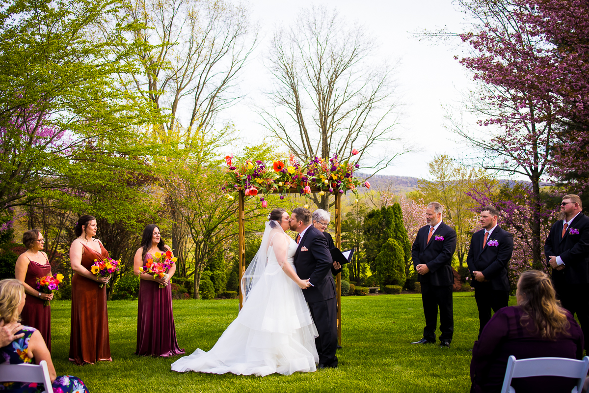 vibrant colorful image of the bride and groom kissing during their linwood estate wedding ceremony