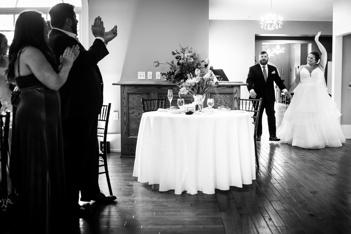 black and white image of the bride and groom entering their wedding reception at linwood estate in carlisle pa 
