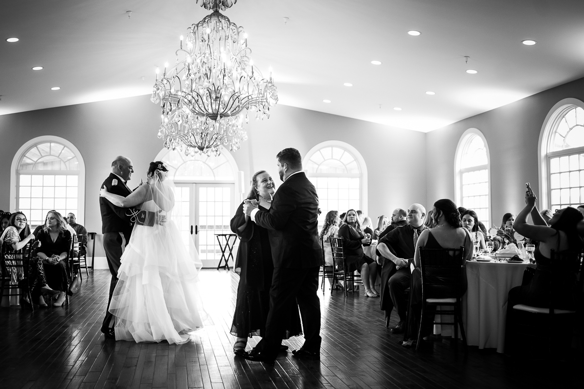 Black and white image of the bride dancing with her father while the groom dances with his mom during their linwood estate wedding reception