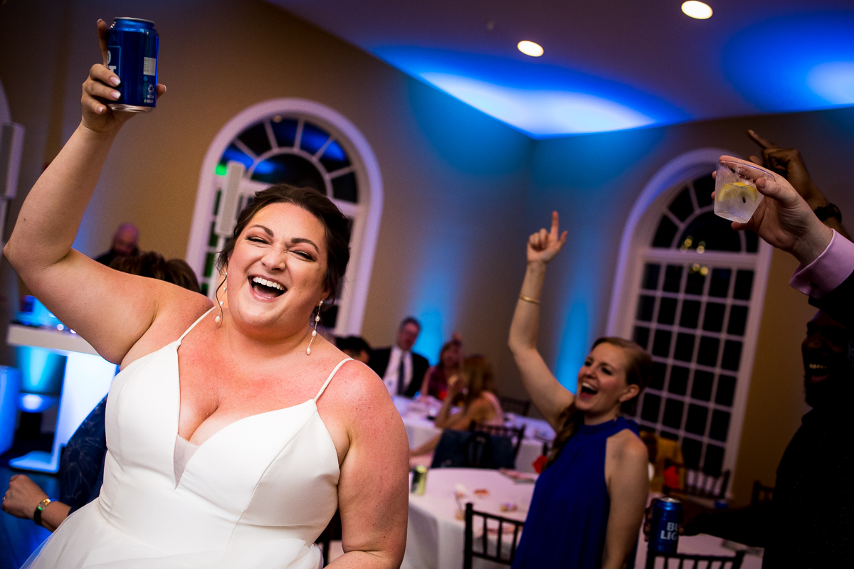 image of the bride holding up a can as they begin to dance during their wedding reception at linwood estate