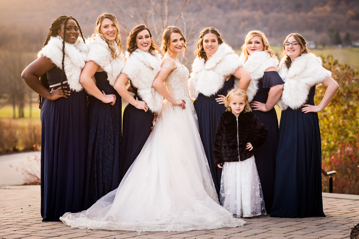 Traditional portrait of the bride and her bridesmaids in their navy dresses and fur shaws at this Liberty Mountain resort wedding with photographer done by central pa photographer Lisa Rhinehart