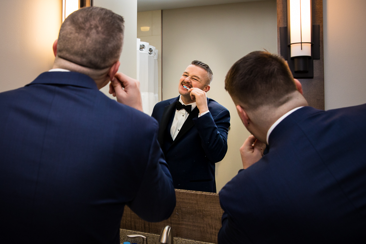 Rhinehart photography, a wedding photographer, captures some groomsmen brushing their teeth before this Liberty mountain wedding ceremony