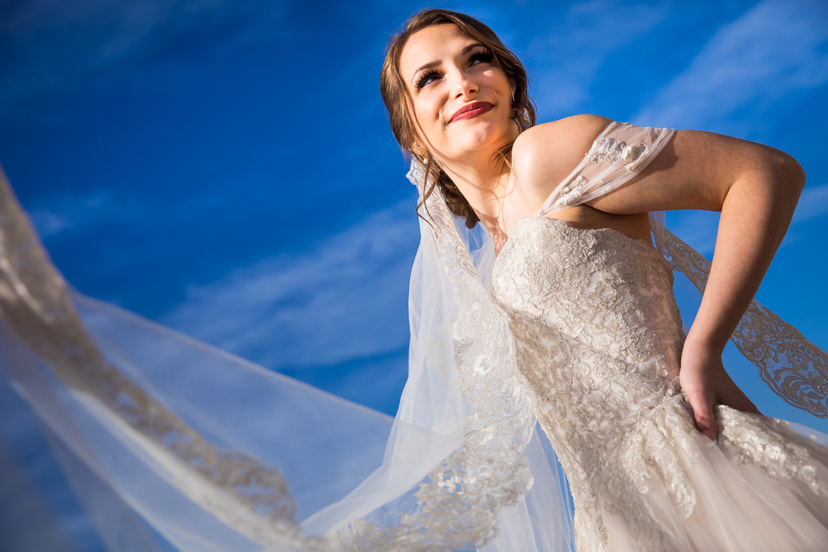 Vibrant blue sky background with the bride looking away from the camera smiling during her first look before her liberty mountain wedding ceremony