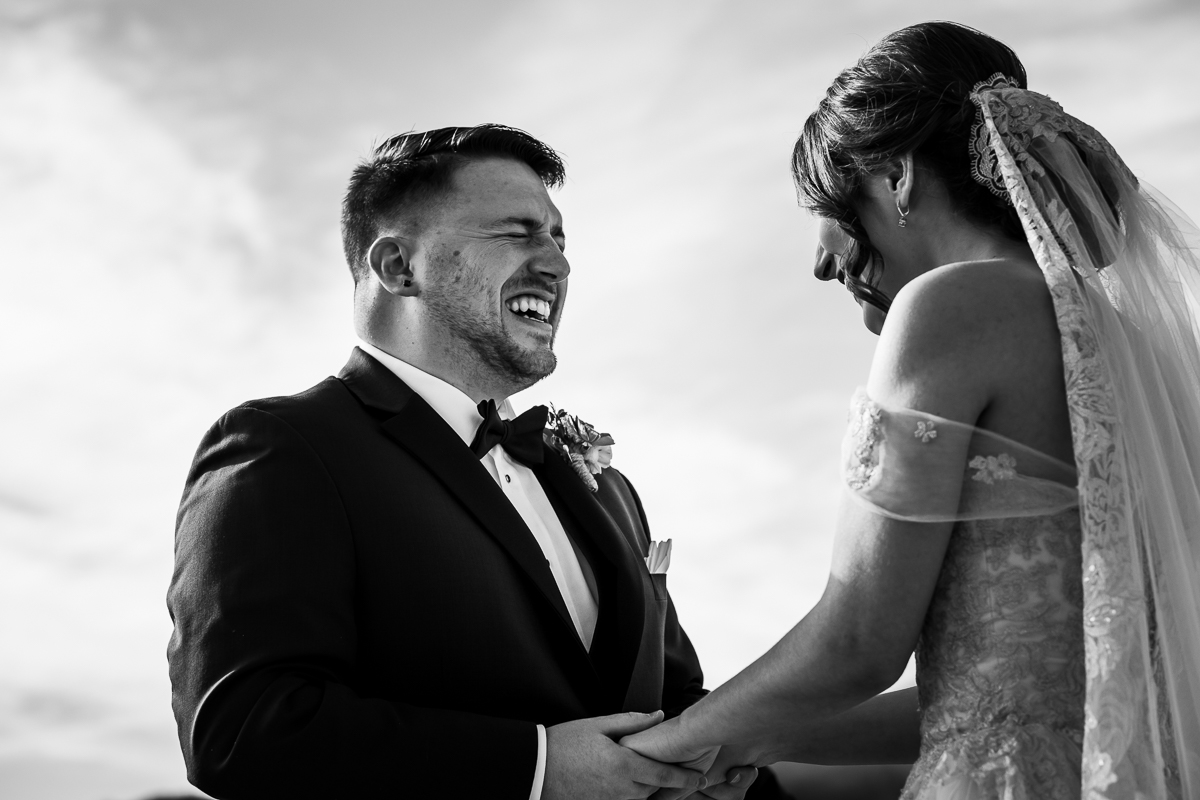 Black and white image of the groom holding the brides hands smiling during their first look before their wedding ceremony at Liberty Mountain Resort
