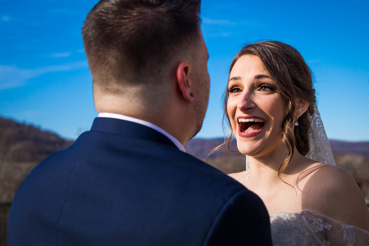 Vibrant, colorful image, tahen by Pennyslvania wedding photographer Lisa Rhinehart, of the bride smiling at the groom before their liberty mountain wedding ceremony 