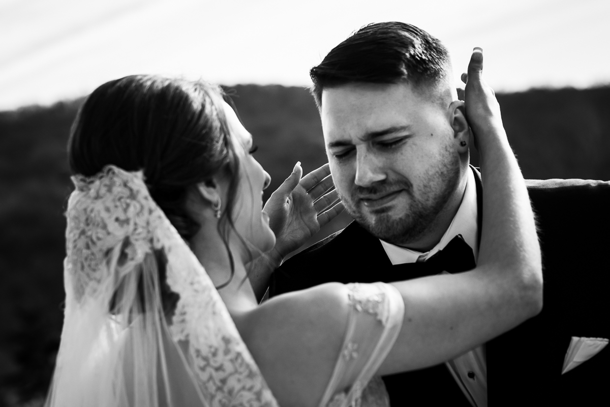 Black and white image of the bride hugging the groom as he cries after seeing her for their first look before their Liberty Mountain resort wedding ceremony