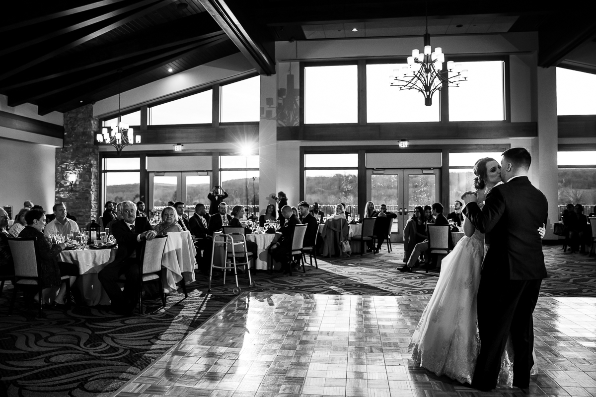 black and white image of the bride and groom dancing their first dance as they kiss on the dance floor for this liberty mountain resort wedding reception