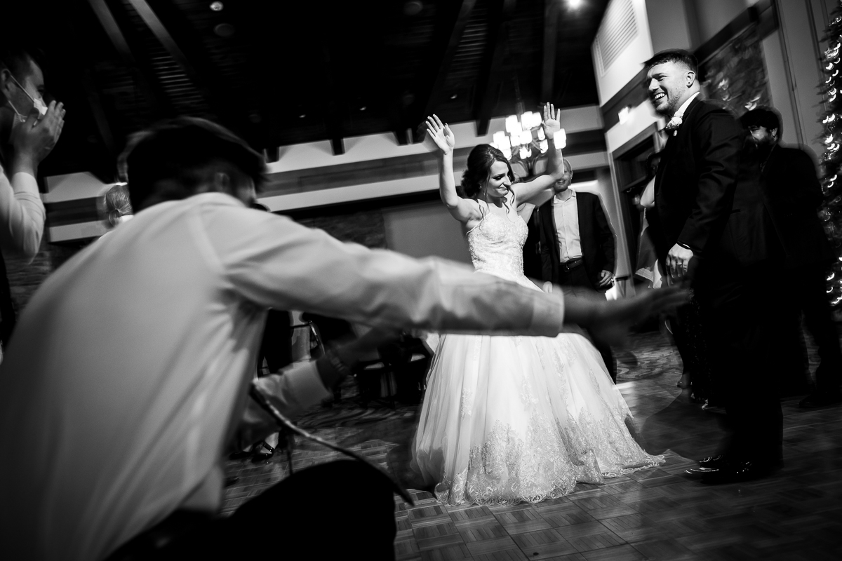 black and white image of the bride and groom dancing together with guest dancing around them during their wedding reception at liberty mountain