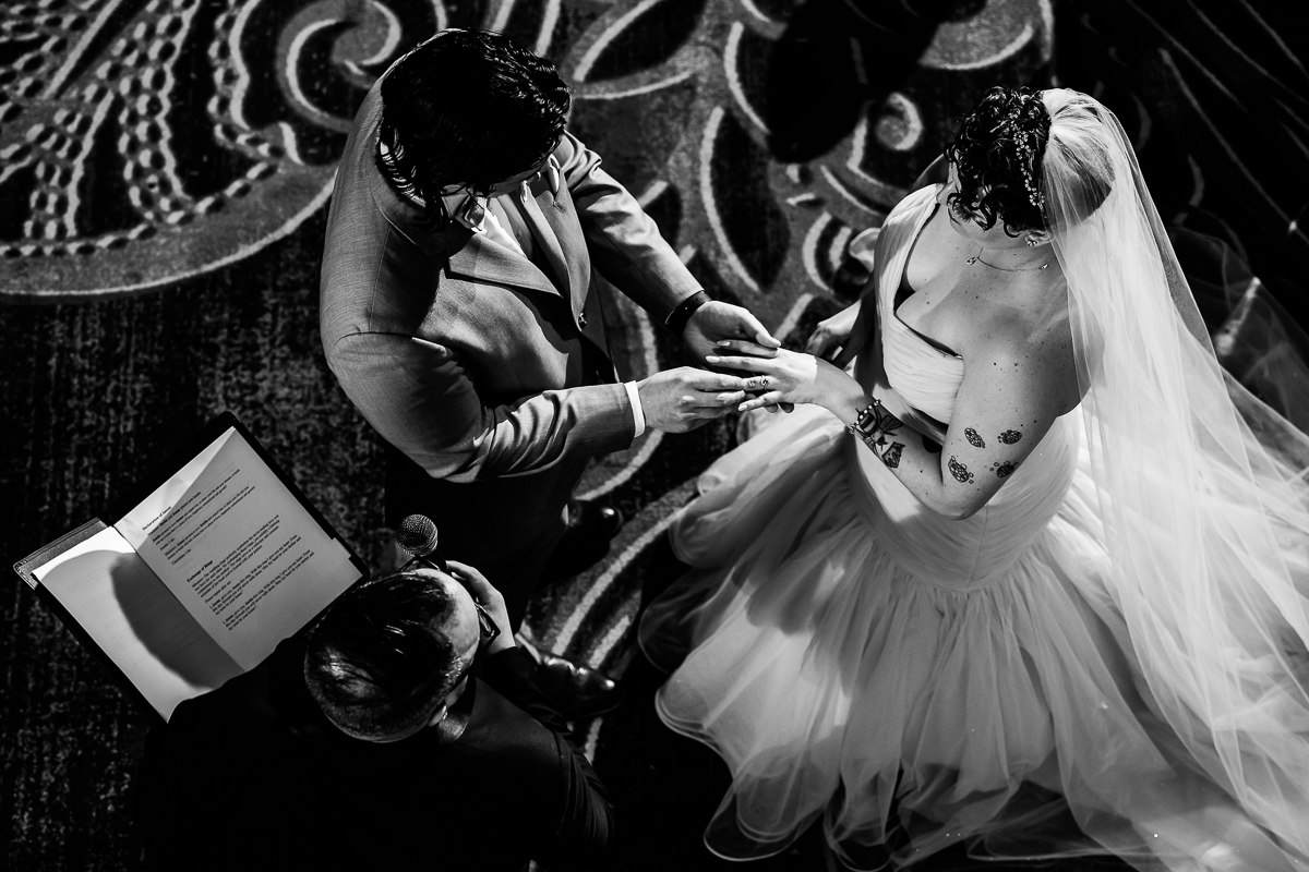 unique, creative angle of the bride and groom exchanging rings from above in this black and white image taken by Palace at Somerset Park Wedding photographer, lisa rhinehart