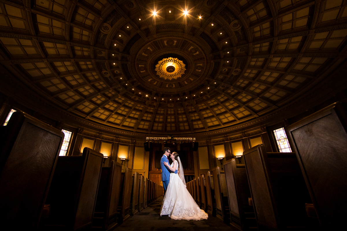 Unique image of the couple standing inside the church for their photos during their Rochester NY wedding 