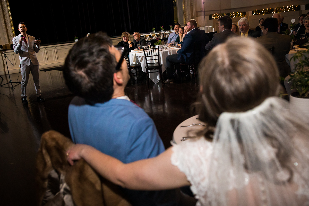image of the bride and groom laughing as their wedding party gives speeches during their wedding reception in Rochester