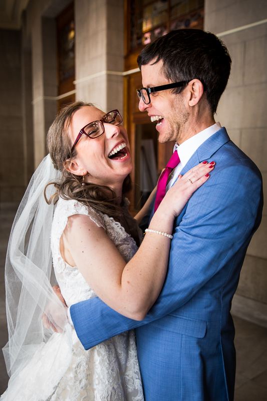 candid photo of the bride and groom laughing as they hug one another before their wedding in Rochester with photographer lisa rhinehart
