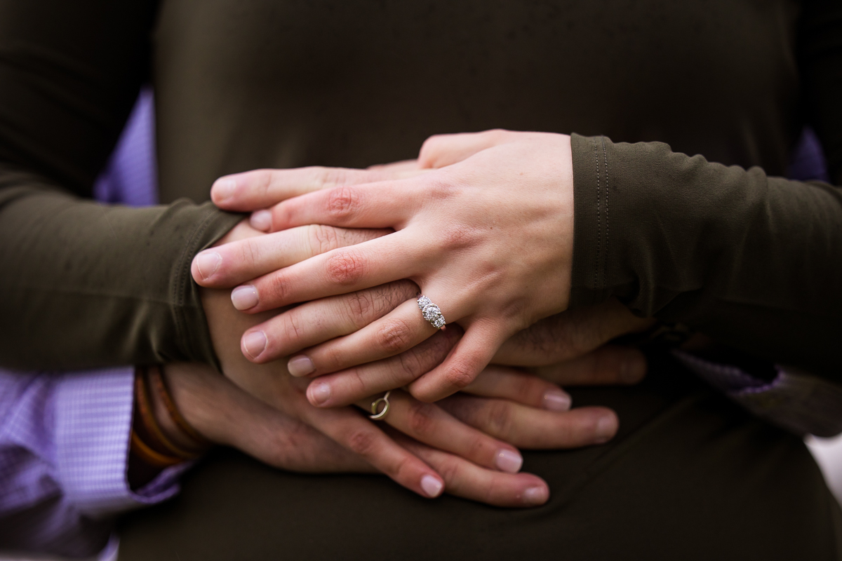 traditional image of the couple holding hands and showing off the engagement ring during their session