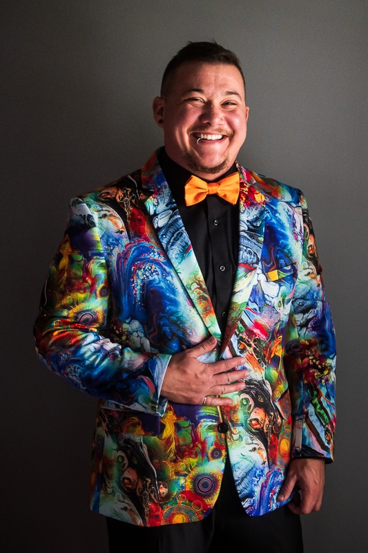 LGBTQIA+ Wedding Photographer, Lisa Rhinehart captured an image of the groom in his colorful, vibrant, unique tuxedo during preparation photos before their backyard wedding ceremony in pennsylvania