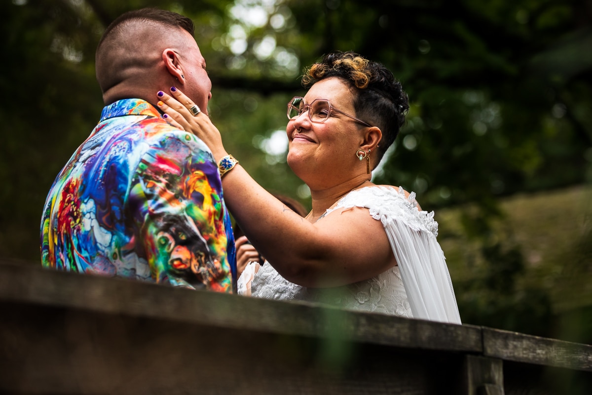 LGBTQIA+ Wedding Photographer, Lisa Rhinehart captures this trans and queer couple during their first look in their unique, vibrant, and colorful wedding attire 
