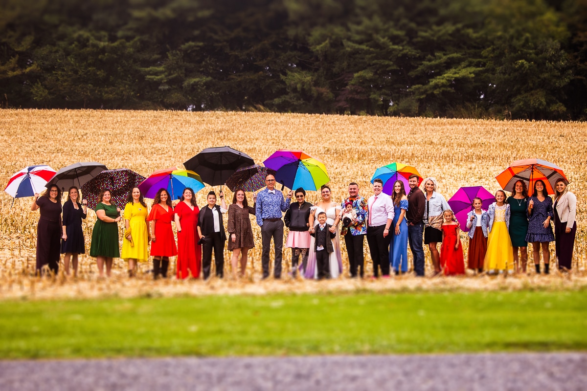LGBTQIA+ Wedding Photographer, Lisa Rhinehart captures the huge wedding party which is all dressed in different colors to represent the LGBTQIA+ community before this backyard wedding in pa 
