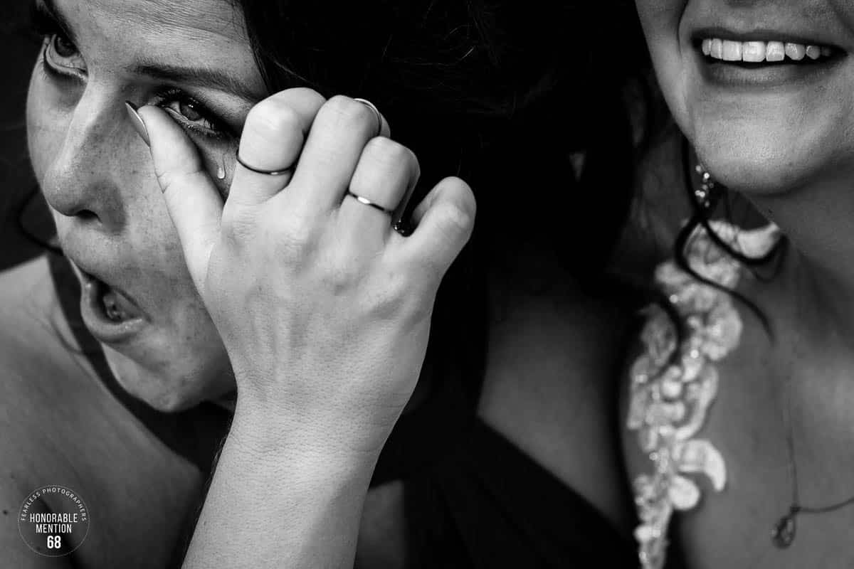 This Fearless photographer honorable mention is a crisp, black and white photo of two people hugging with a close up of a lady whipping a tear from her eye