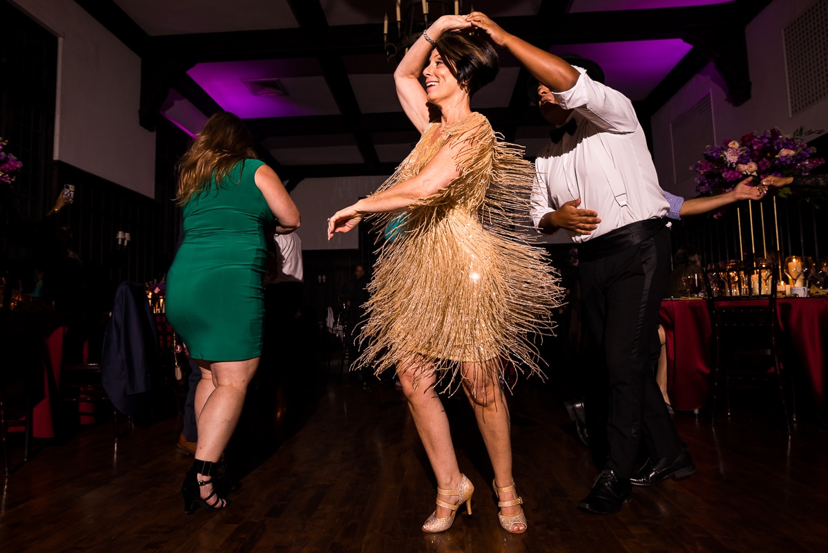 Image of the bride in a gold fringe dress for salsa dancing lessons during this Harrisburg civic club wedding reception