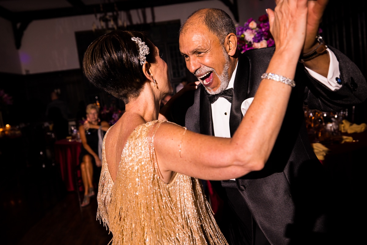 the bride in a gold fringe dress and a guest dancing together during this civic club of Harrisburg wedding reception