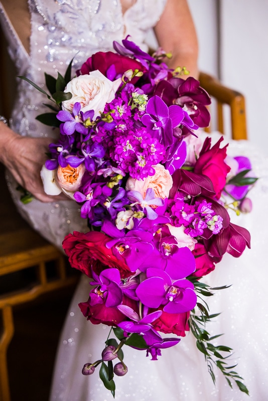 Colorful and vibrant photo of the bride holding her bouquet which consists of purple, pink and white flowers for this Harrisburg Civic club wedding, this photo was taken by Lisa Rhinehart a Harrisburg wedding photographer 