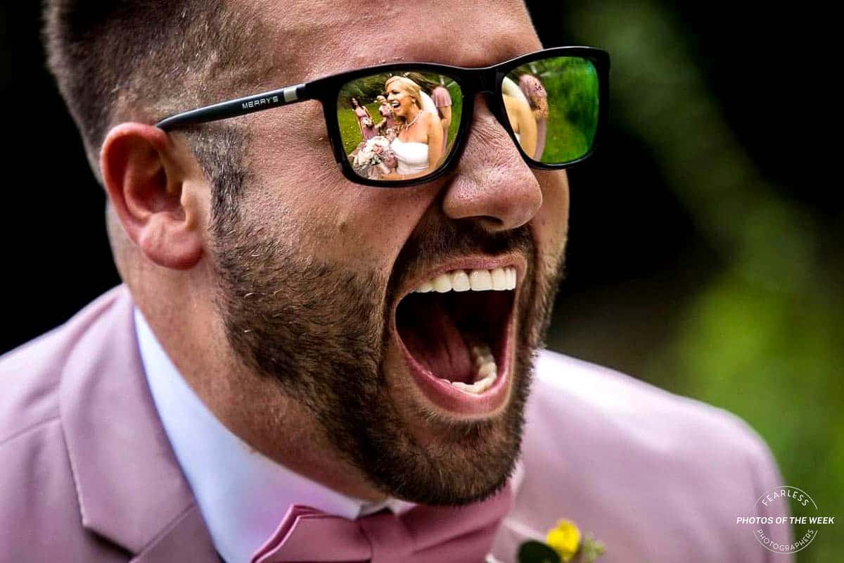 Fearless Photographers photo of the week features Lisa Rhinehart Photography's creative image featuring a man smiling big at the bride and her reflection is caught in his sunglasses best wedding photographers in dc 