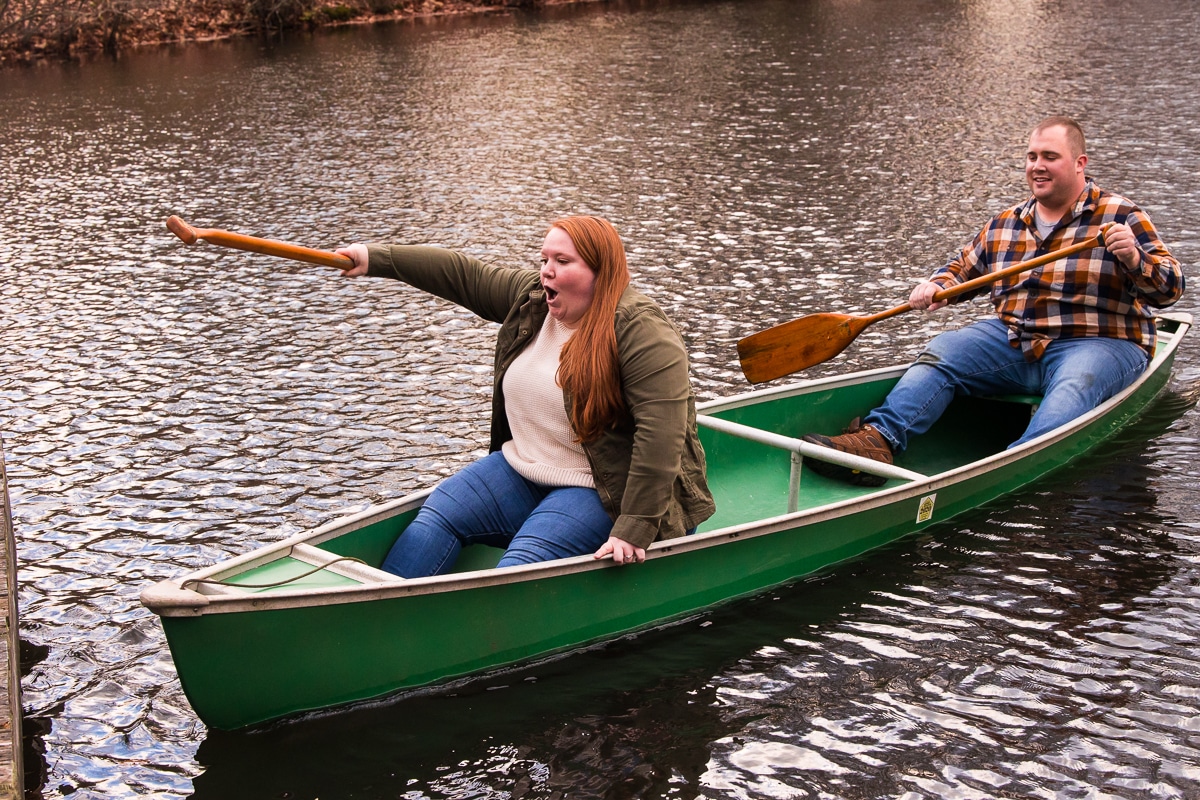 Engagement photographer, Lisa rhinehart, captures the couple in a green canoe out on the pond during their fall session